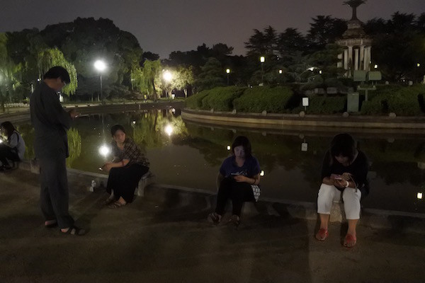 大勢の人が無言で公園に集まっている姿は異常